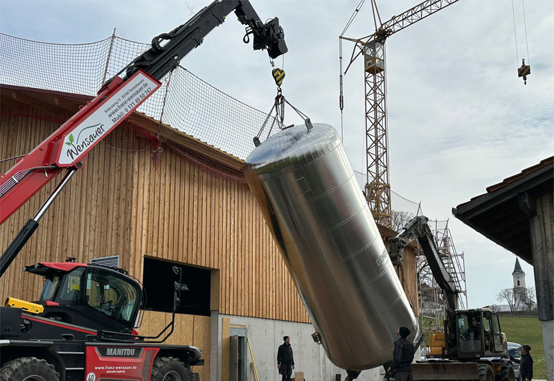 Der Pufferspeicher wird mit einem Teleskoplader angehoben.